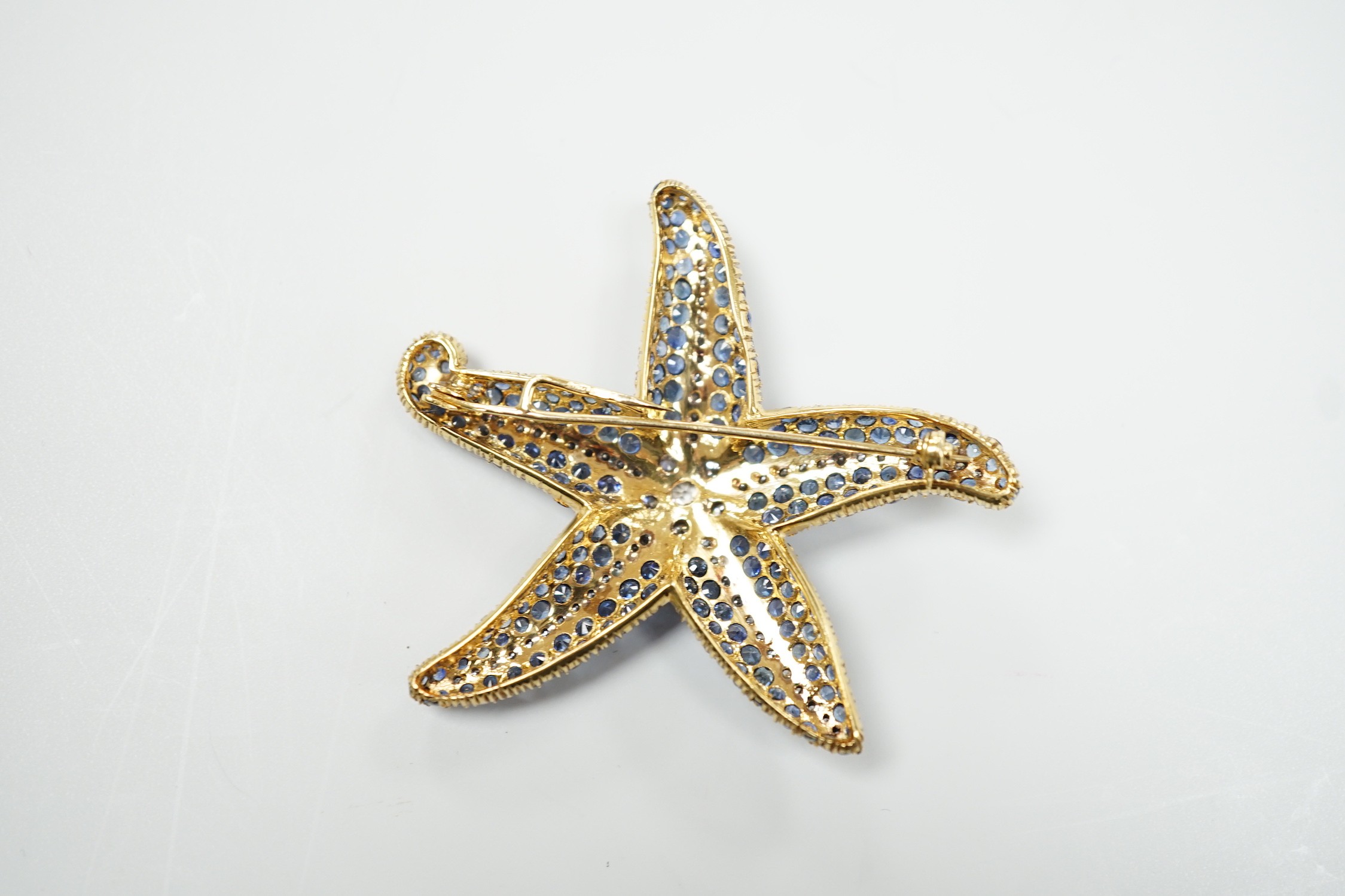 A mid to late 20th century 750 yellow metal, sapphire and diamond cluster set starfish brooch, maker, PA AP? 54mm, gross weight 19.3 grams, central stone diameter 4.4mm.